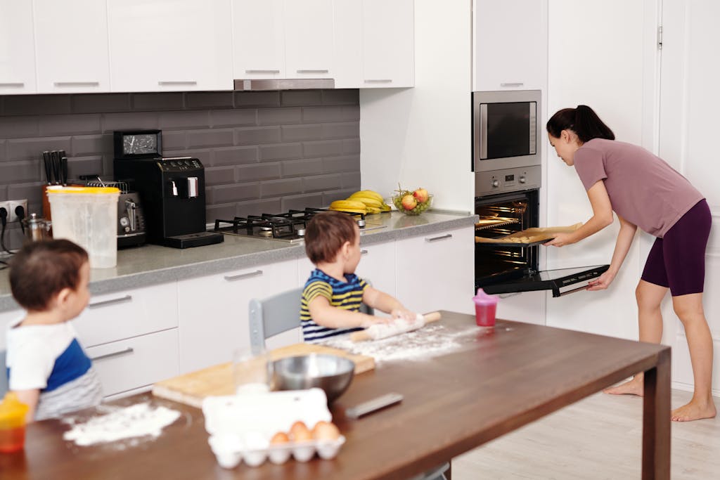 Mother and children baking together in a modern kitchen. Family time and cooking fun.